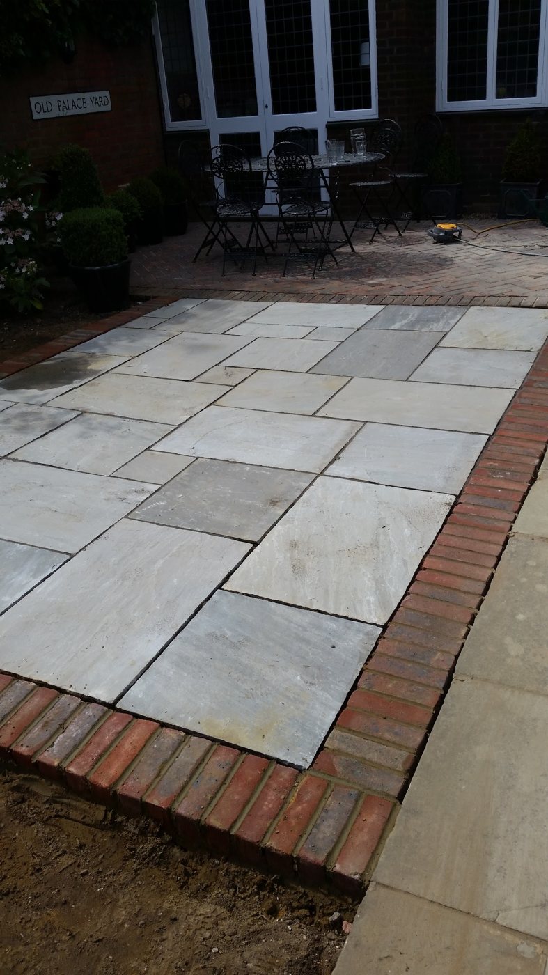 New sandstone patio with brick edging